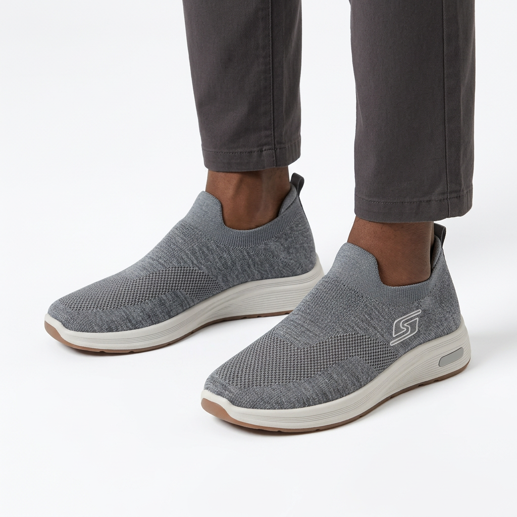 Grey knit slip-on sneakers worn on both feet