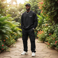 Nigerian male model wearing black sweatshirt with cursive script chest graphic – front view