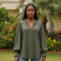 Nigerian female model wearing olive army green bishop sleeve blouse with ruffle V-neckline and smocked cuffs