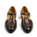 Pair of dark brown croc-embossed buckle cutout shoes on white