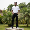 Nigerian male model full body wearing men's black planet embroidered flared denim jeans