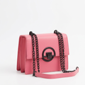 Pink structured shoulder bag with dark chain strap and circular front clasp on white