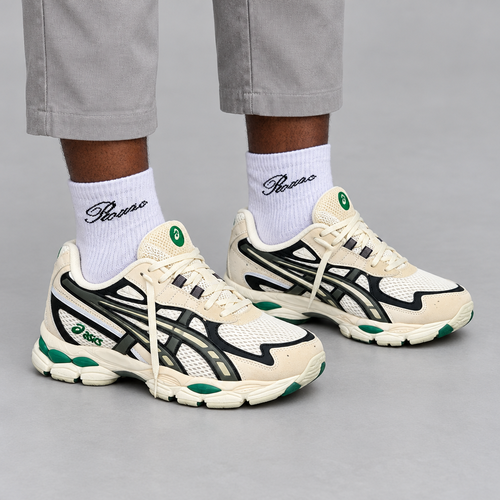 Lower-leg view of Nigerian man wearing cream mesh sneakers with green accents, both shoes visible