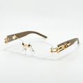 Clear rimless glasses with gold-tone link details and taupe-brown arms on white