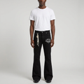 Man wearing black graphic flared trousers on plain studio background
