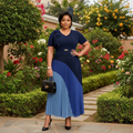 Nigerian female model wearing navy and steel blue colour-block pleated midi gown in garden setting