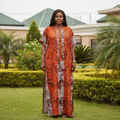Nigerian female model wearing rust geometric print bubu kaftan dress in garden setting