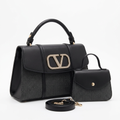 Black patterned-panel top-handle handbag with sparkling ornament beside smaller button-flap bag and strap