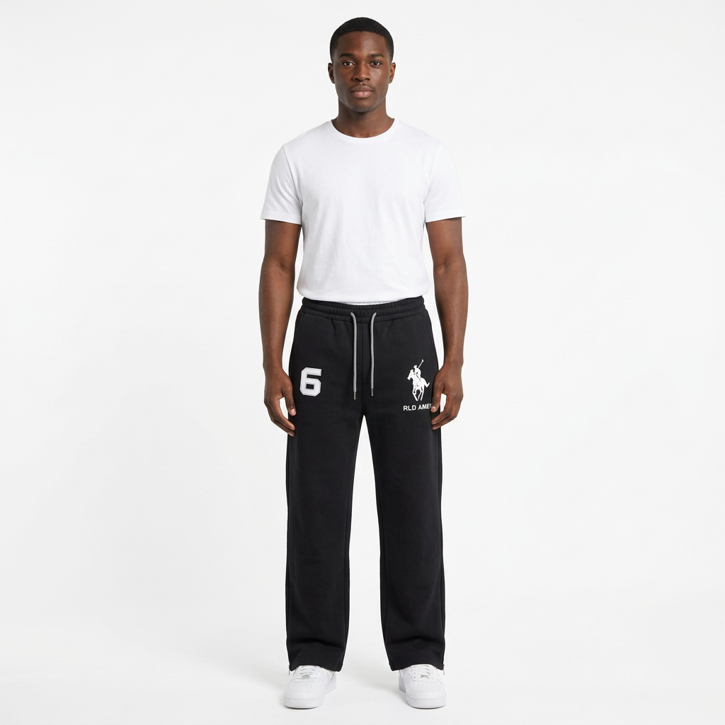 Black male model wearing black graphic drawstring trousers on a white studio background