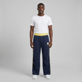 Full-body male model wearing navy and yellow track trousers