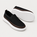 Pair of black textured slip-on sneakers with brown trim and white sole
