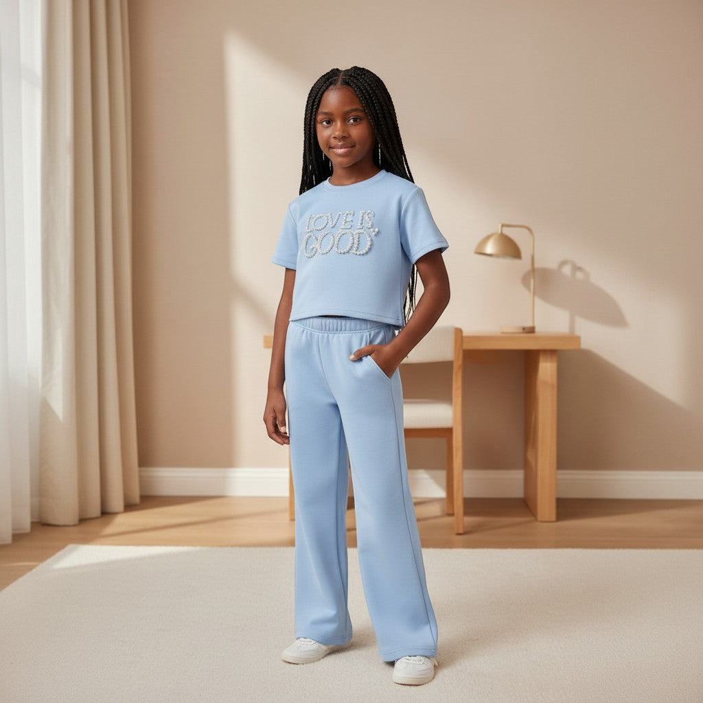 STEEZU girls' sky blue crop tee with "Love Is Good" pearl embellishment and matching wide-leg sweatpants.