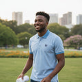 STEEZU sky blue polo shirt with white micro-stripes, contrast blue collar, and chest emblem. Short sleeves.