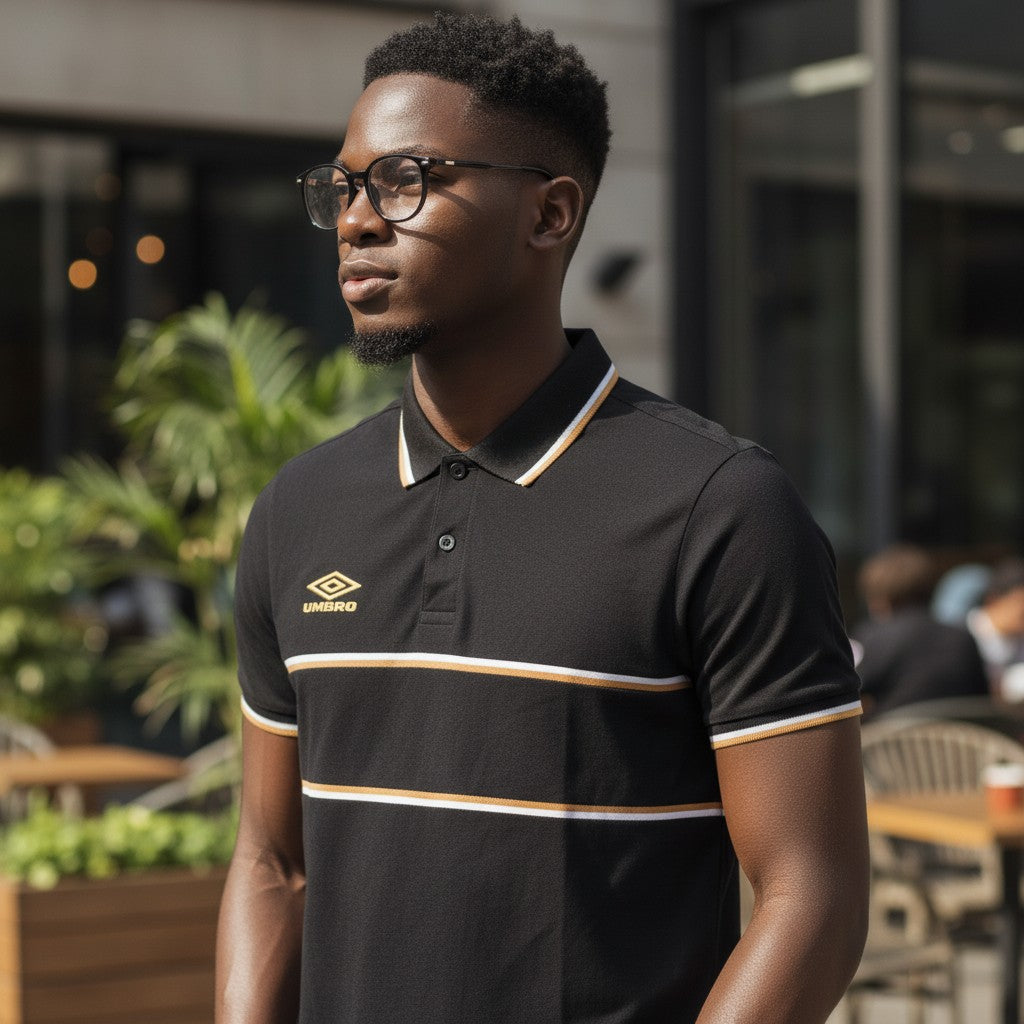 STEEZU Umbro black polo shirt with gold and white chest stripes, gold logo, and striped collar and cuffs.